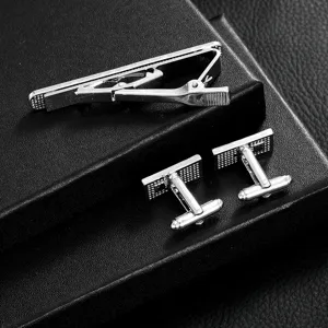 Detail view of men business silver alloy tie clip and cufflink set on black box surface.