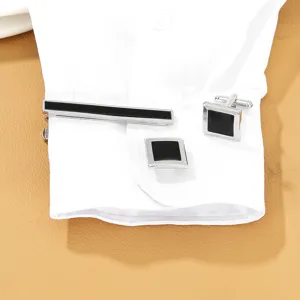 Classic mens silver-tone tie clip and square black cufflink set for business formal wear.