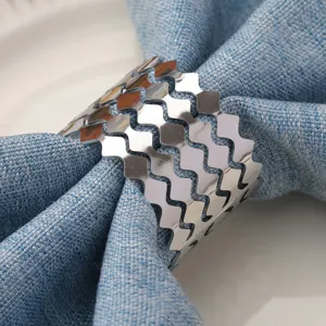 Primo piano di un portatovaglioli in metallo argentato ondulato per un'elegante decorazione della tavola.