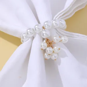 Close-up of elegant pearl napkin ring with gold chain pendants, luxury table decor detail.