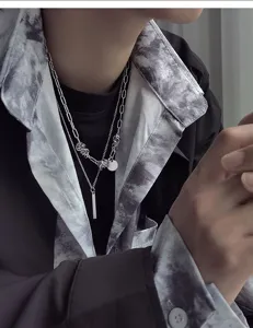 Gros plan détaillé du collier à double chaîne en métal élégant avec pendentif géométrique.