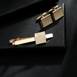 Gold-tone men's tie clip and cufflinks set featuring a textured geometric design for business.