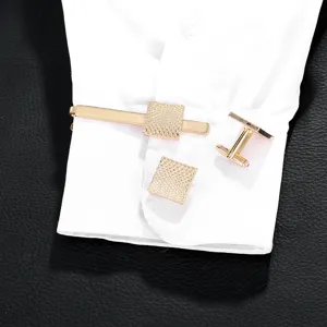 Men's gold tie clip and cufflink set with textured square design, elegant business accessory.