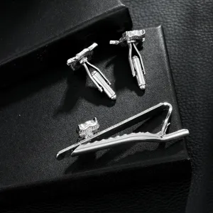 Detailed view of silver astronaut tie clip and cufflinks set, elegant metal texture and craft.