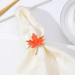 Dettaglio portatovagliolo foglia d'acero arancione, decorazione tavola autunnale e stoffa.