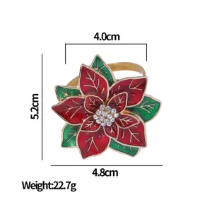 Christmas poinsettia napkin ring with red petals, green leaves, rhinestones, and gold trim.