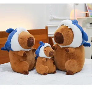 Capybara plush toy with shark hat, cute stuffed animal doll set details and cozy bedroom display.