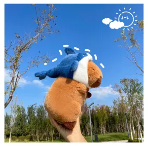 Cute capybara plush toy wearing blue shark hat, soft stuffed doll for kids birthday gifts.