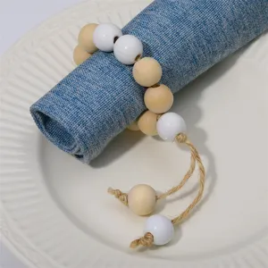 Detailed shot of wooden bead napkin ring with jute tassel, rustic table decor accessory.