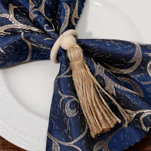 Wooden napkin ring with hemp rope tassel and blue fabric napkin for dining table decor.