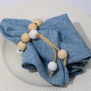 Handmade wooden bead napkin rings with jute rope tassel for elegant table setting decor.