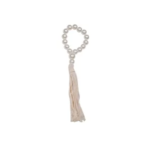 Elegant pearl napkin ring with beige tassel, perfect for home dinner table and hotel decor.