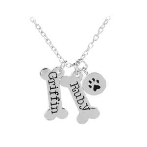 Gepersonaliseerde zilveren botvormige ketting met gegraveerde namen en een leuke pootafdruk hanger.