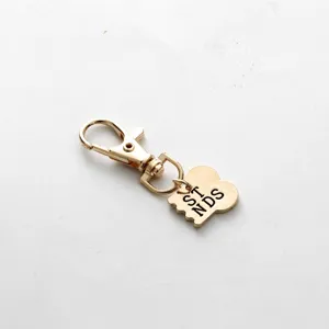 Gedetailleerd shot van gouden legering sleutelhanger hanger met kreeftsluiting design.