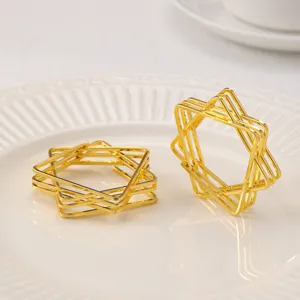 Modern geometric metal napkin ring in gold star design, perfect for dining table decor.