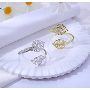 Detailed view of hollow leaf napkin rings, elegant gold and silver metal table decor.
