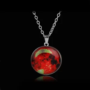 Close up of a glowing round gemstone pendant necklace with silver chain and starry moon design.