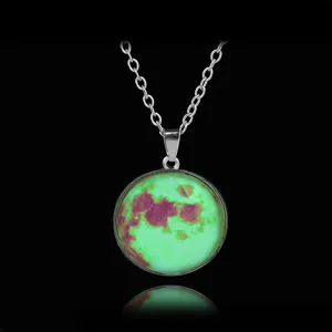 Close-up detail of the glowing moon glass pendant necklace showing the luminous starry texture.