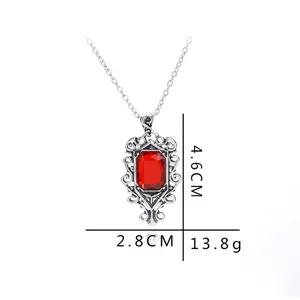 Collier pendentif pierre précieuse rouge vintage avec cadre argenté orné, bijou rétro chic.