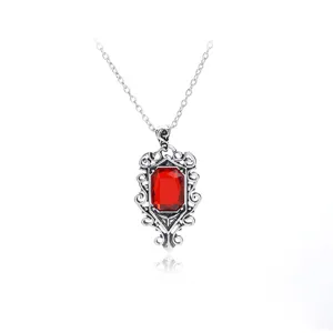 Vue détaillée du collier pendentif rubis vintage, mettant en valeur son cadre argenté sculpté.