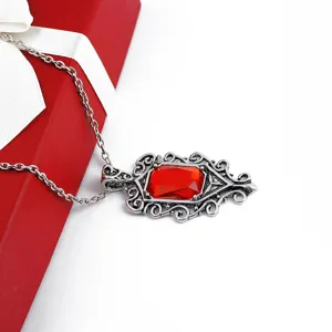 Vue détaillée d'un collier pendentif en cristal rouge vintage avec monture argentée.
