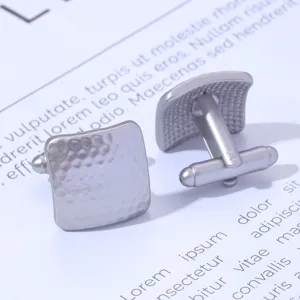 Detail view of men's square hammered metal cufflinks, elegant business accessory.