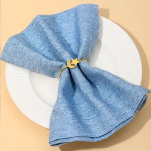 Détail de rond de serviette lune et étoile dorées design en métal élégant pour table.
