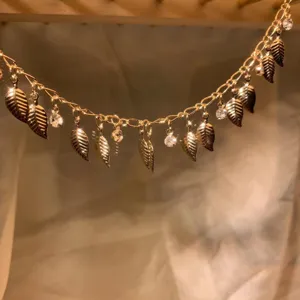 Gold leaf zircon chain detail shot, dangling DIY accessory trim for exotic forehead or waist.