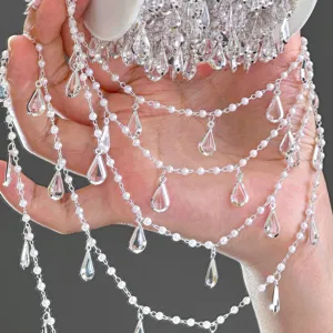 Gros plan détaillé de la chaîne de taille multicouche DIY perle blanche et cristal.