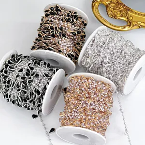 Gros plan de diverses chaines de cristaux en perles DIY enroulees sur des bobines blanches.