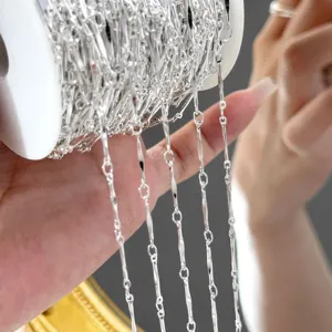 Gros plan de chaîne plate en métal argenté DIY sur bobine pour la création de bijoux.