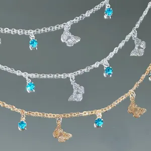 DIY metal chain detail featuring blue rhinestone pendants and hollow butterfly charms.