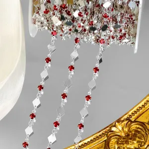 Vue détaillée de la chaîne de bricolage avec pièces en métal losangées et strass rouges.