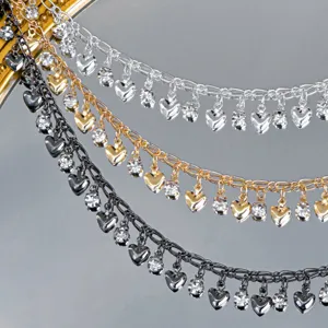Close-up detail showing colorful metal chains with heart charms and sparkling rhinestones for DIY crafts.