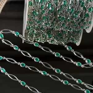 Gros plan sur chaîne de bijou artisanale ovale vert menthe, détail de bricolage.