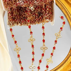Chaine de bijoux rouge et or quatre feuilles accessoire de couture detail gros plan vue