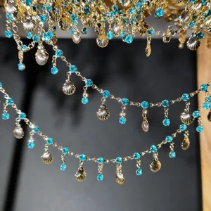 Close-up details of DIY Chinese style hair accessory chain with blue rhinestones and shells.