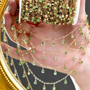 Detailed view of gold-colored DIY rhinestone chain with green crystal drops for handmade jewelry.