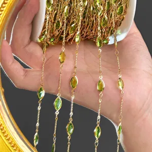 Detailed view of DIY gold-tone chain with green marquise stones for jewelry making.
