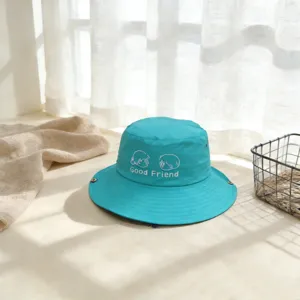 Vista detallada de un sombrero de pescador azul para niños con bordado lindo y texto divertido.