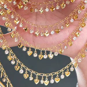 Close-up of gold DIY chains with heart charms and rhinestones for decorative crafts and accessories.