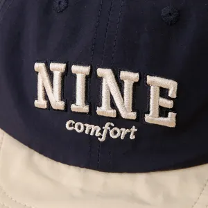 Detalle en primer plano de gorra de béisbol infantil con letras bordadas, tela transpirable.