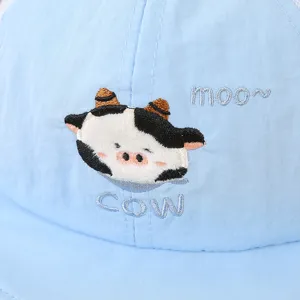 Primer plano detallado de gorra de béisbol azul para niños con bonito bordado de vaca.