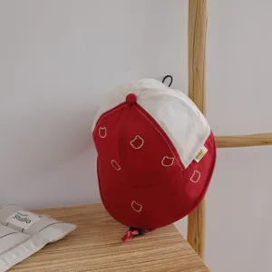 Detail view of children's breathable mesh bucket hat with cute bear embroidery, red and white.