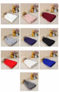 Detailed view of winter knitted beanie hats with fluffy fur pom-poms in various color options.