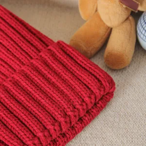 Red knit beanie hat detail view, thick ribbed winter warm woolen cap close up texture show