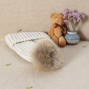 Women's winter warm knitted beanie hat with fluffy fur pom pom, thick and soft casual headwear.