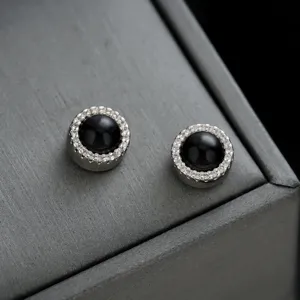 Elegantes pendientes magnéticos redondos con piedra negra y cristales brillantes.