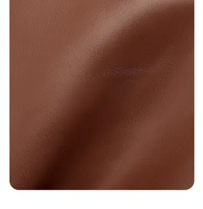 Brown leather fabric detail texture closeup showing soft grain and premium quality.