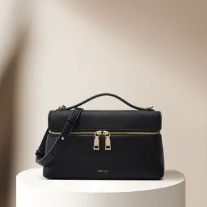 Black lychee pattern leather cosmetic bag detail, retro underarm handbag with gold zipper.